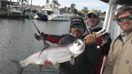 Captain George Hastick holding a large Tarpon and enjoying Fred Howard Park trout fishing