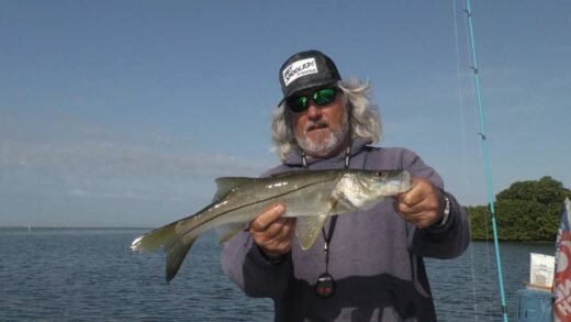 Captain Rick Liles holding a freshly boat caught fish on a trip Trout and Snook Fishing in Ruskin, Florida.