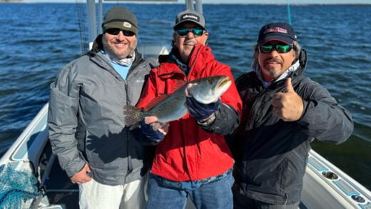 Three anglers on boat displaying speckled trout catch on Florida's Nature Coast