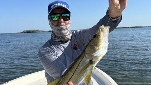 Angler in Yamaha cap holding large Pine Island Snook