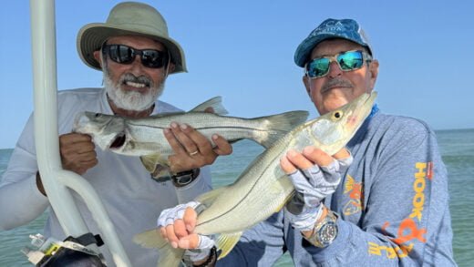 Two smiling fishermen holding Snook caught on a Captiva Fishing trip