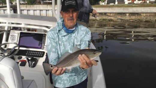 Redfish tactics result in an angler holding a redfish caught during a low tide fishing trip