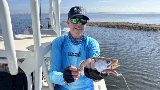 Captain Sergio Atanes holding a speckled trout caught during negative tide conditions in Tampa Bay