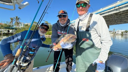 Winter fishing surprises - three fishing captains display a large fish in caught during a winter fishing expedition